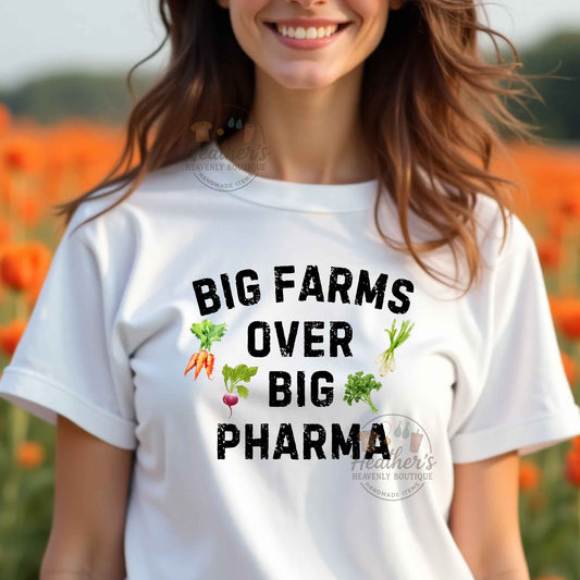 Person wearing a white t-shirt with 'BIG FARMS OVER BIG PHARMA' text and vegetable graphics in a field.