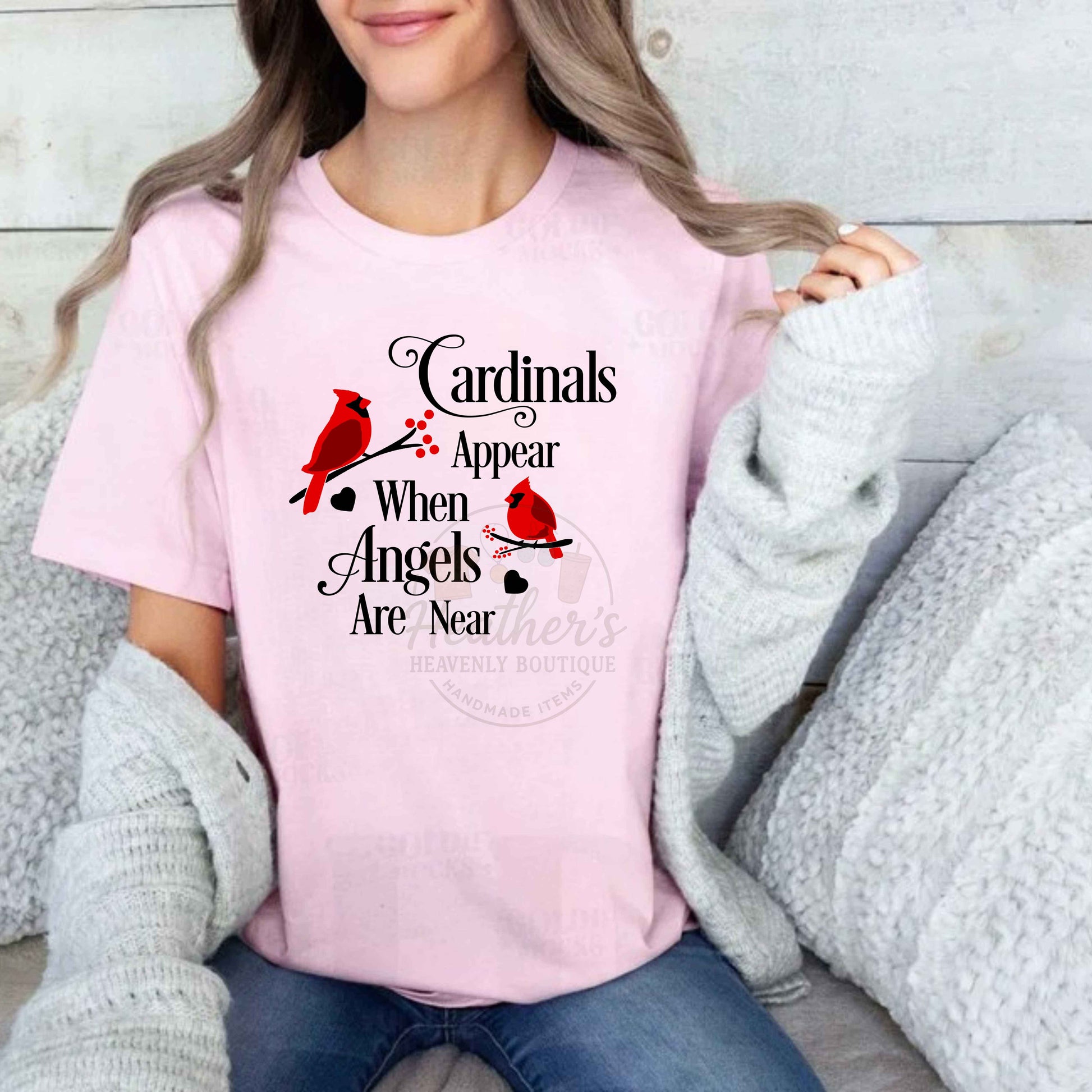 Person wearing a pink t-shirt with cardinals appear when angels are near design and text.
