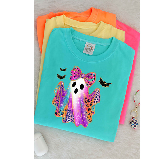 Colorful t-shirt with a ghost design featuring a bow and bats on a light gray surface.