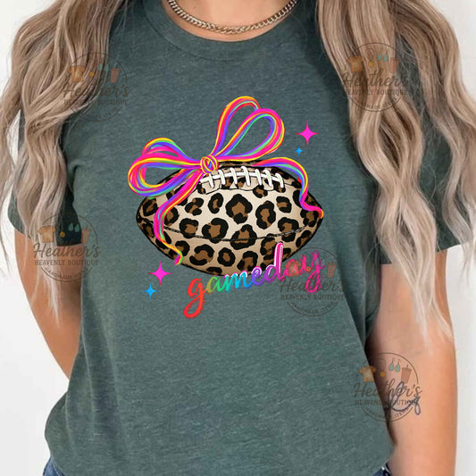 Green t-shirt with leopard print football and colorful bow design on a plain background