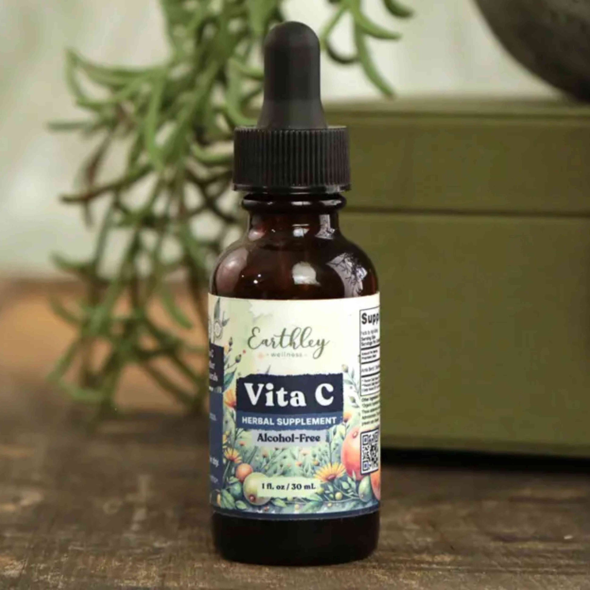 Vita C supplement bottle with dropper on a wooden surface with a plant in the background