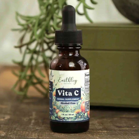 Vita C supplement bottle with dropper on a wooden surface with a plant in the background