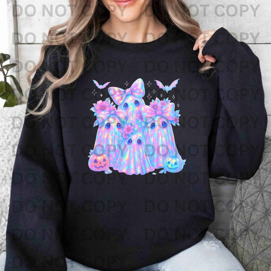 Person wearing a black sweatshirt with colorful ghost design and Halloween elements.