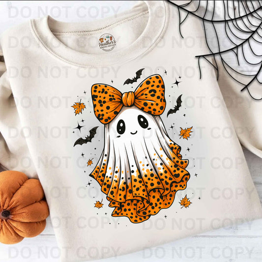White sweatshirt with a ghost design wearing an orange bow, surrounded by Halloween elements on a light background.